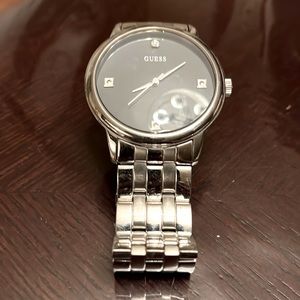 Silver-toned, black faced mens Guess watch.